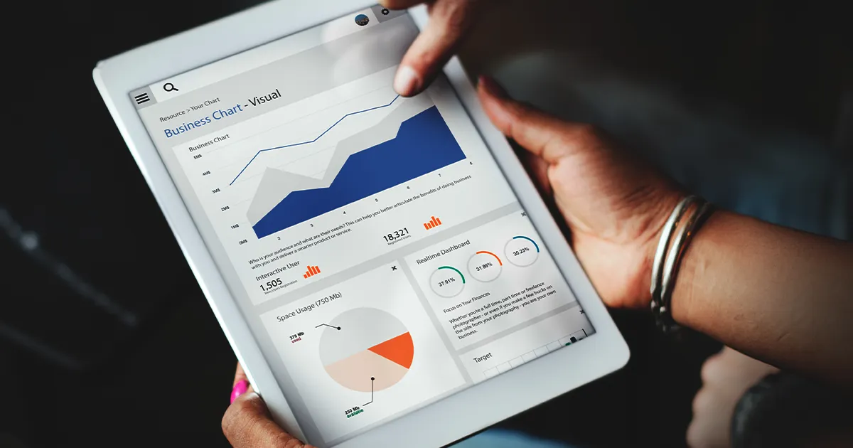Business Analytics Dashboard - Real-Time Performance Tracking on Tablet Person holding tablet displaying business analytics dashboard with performance chart, real-time metrics, and interactive data visualization