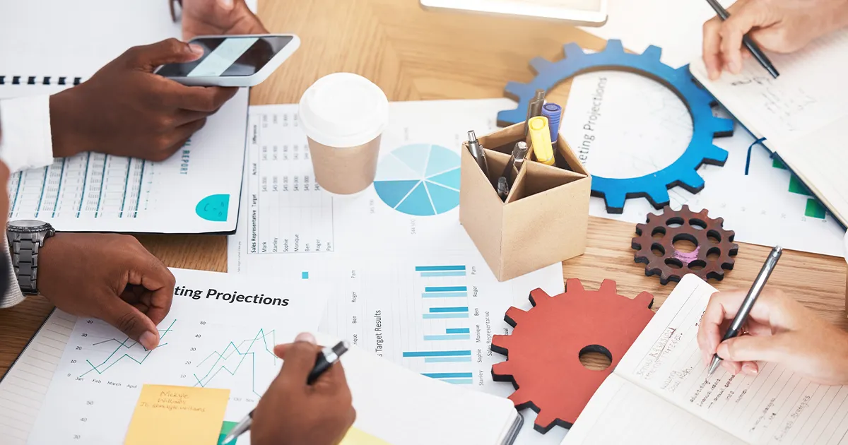 SEO Strategy and Marketing Performance Analysis Workflow Team analyzing marketing projections and sales performance charts with gears symbolizing SEO strategy workflow